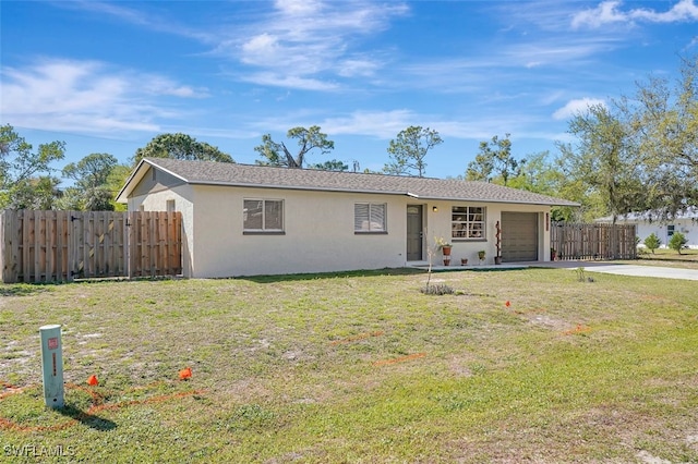 single story home featuring stucco siding, driveway, fence, a front yard, and a garage