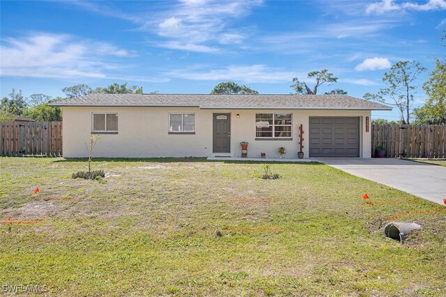 single story home with a front yard, concrete driveway, fence, and an attached garage