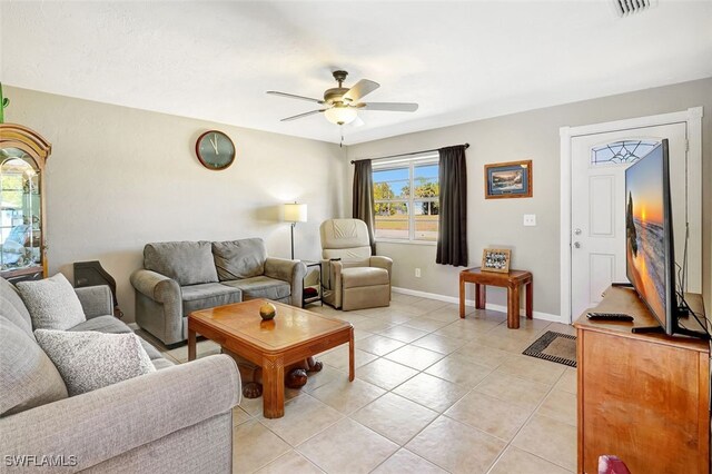 living area with light tile patterned floors, baseboards, visible vents, and a ceiling fan