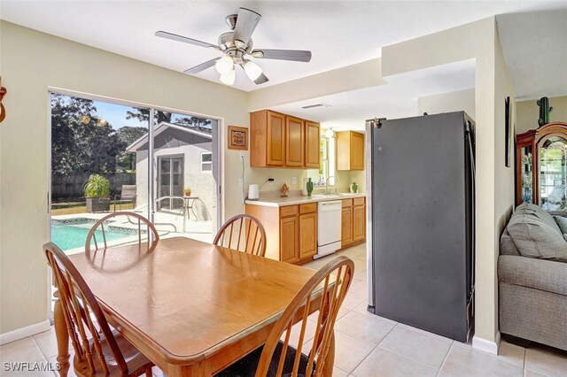 dining space featuring ceiling fan, baseboards, and light tile patterned floors