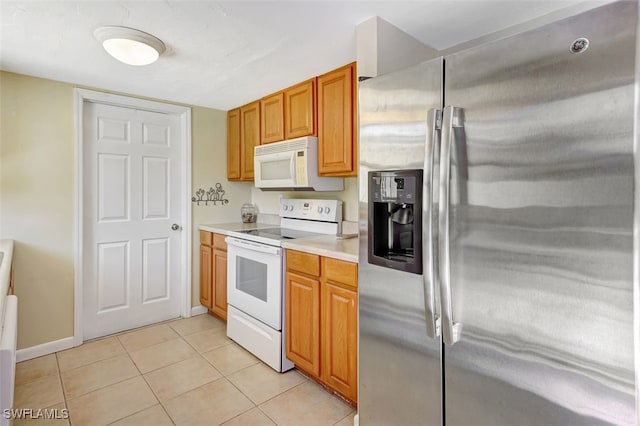 kitchen with brown cabinets, white appliances, light countertops, and light tile patterned floors