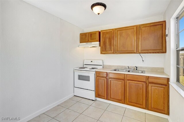 kitchen with electric stove, light tile patterned floors, light countertops, a sink, and under cabinet range hood