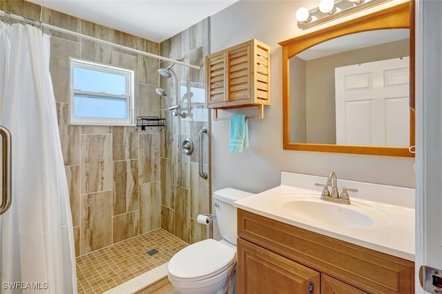 bathroom featuring a stall shower, vanity, and toilet