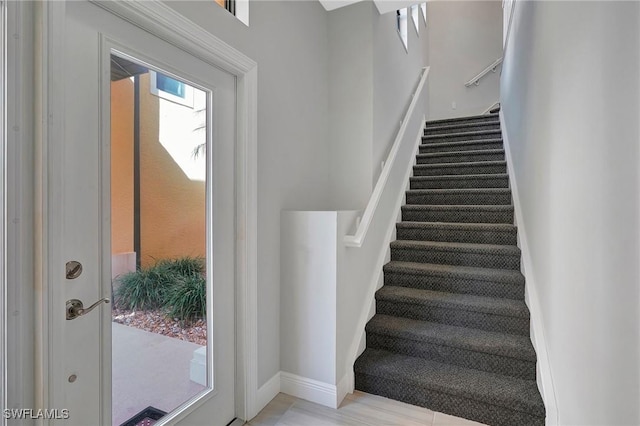 stairway with wood finished floors and baseboards