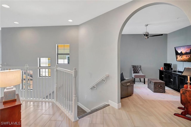 stairs with arched walkways, baseboards, a ceiling fan, and recessed lighting