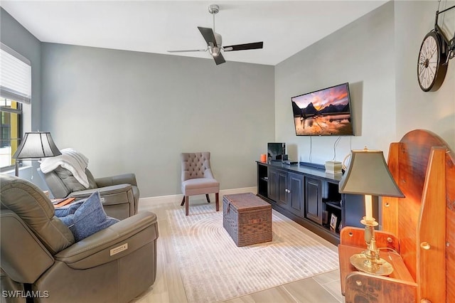living room with baseboards and a ceiling fan