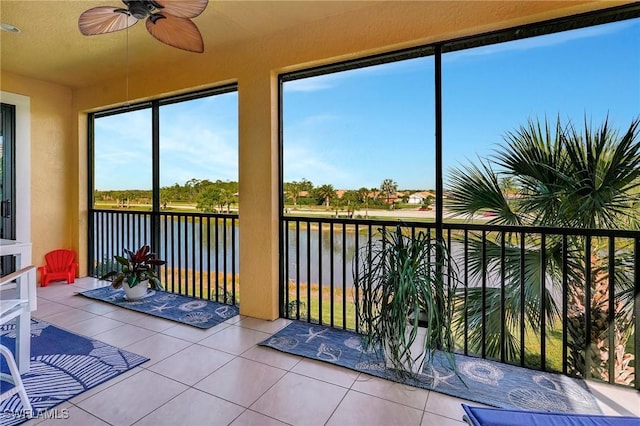sunroom featuring a water view and tile patterned floors