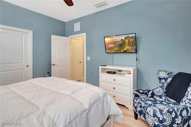bedroom with light wood-style floors, visible vents, and ceiling fan