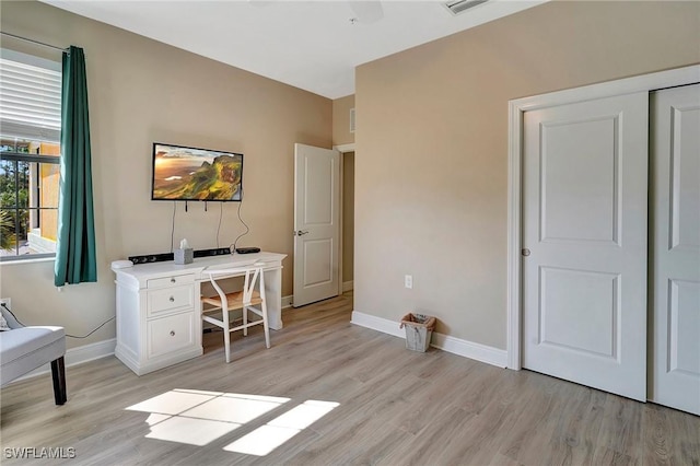 office space featuring light wood-style flooring, baseboards, and visible vents