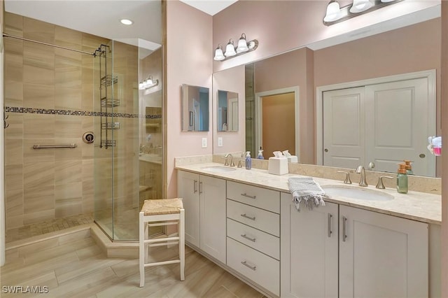 full bath featuring double vanity, a sink, and a stall shower