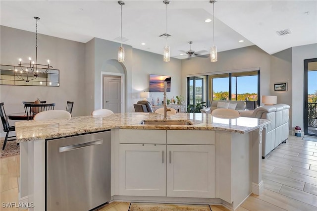 kitchen featuring open floor plan, light stone counters, stainless steel dishwasher, and visible vents