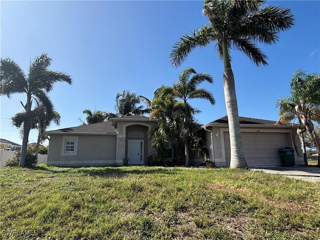 view of front of home with a garage, stucco siding, driveway, and a front yard