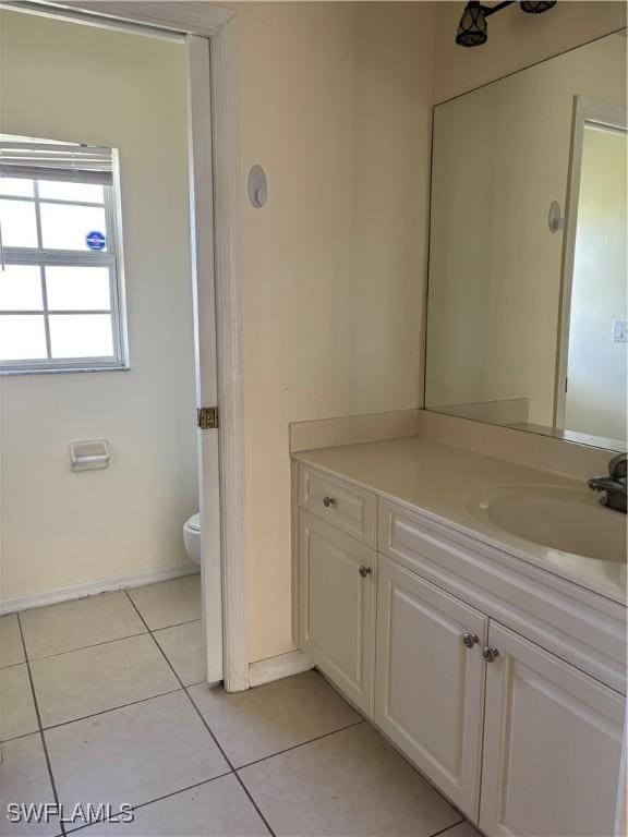 bathroom featuring toilet, baseboards, vanity, and tile patterned floors