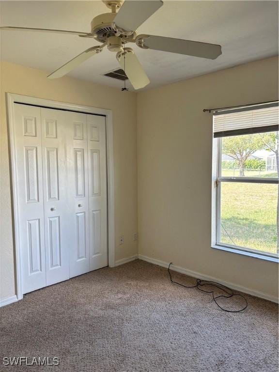 unfurnished bedroom with carpet floors, a closet, visible vents, and baseboards