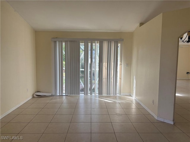 unfurnished room with tile patterned flooring and baseboards