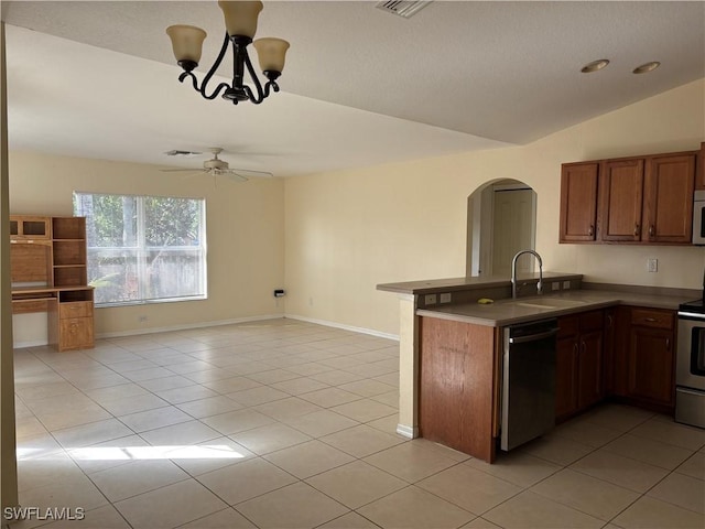 kitchen featuring arched walkways, dishwashing machine, white microwave, lofted ceiling, and a sink