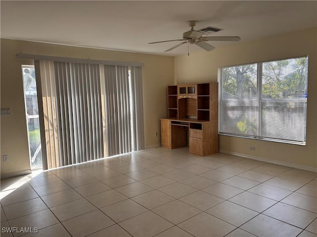 empty room featuring light tile patterned floors, plenty of natural light, visible vents, and baseboards