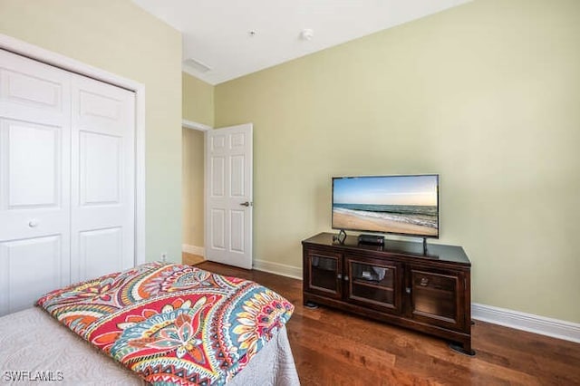 bedroom with a closet, baseboards, and wood finished floors