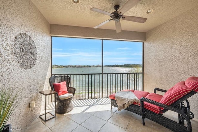 sunroom / solarium featuring a ceiling fan and a water view