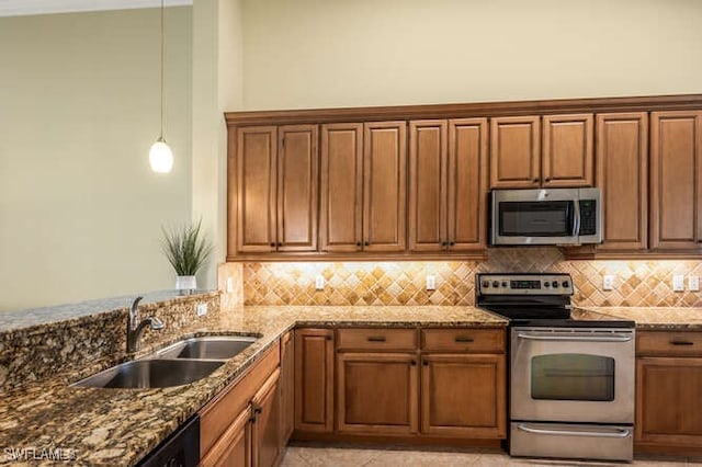 kitchen with tasteful backsplash, appliances with stainless steel finishes, dark stone counters, and a sink