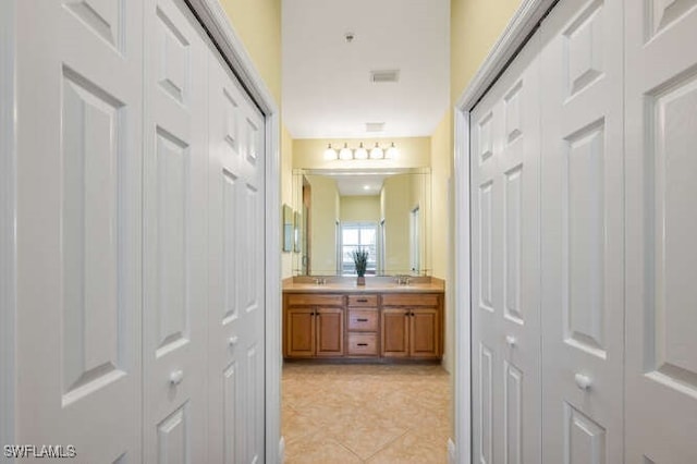 bathroom with tile patterned floors, a closet, and double vanity