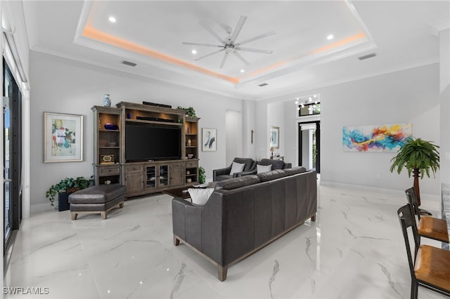 living area with a raised ceiling and baseboards