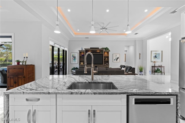 kitchen featuring a kitchen island with sink, a sink, visible vents, open floor plan, and a tray ceiling