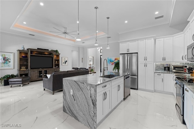 kitchen featuring marble finish floor, appliances with stainless steel finishes, a raised ceiling, and a sink