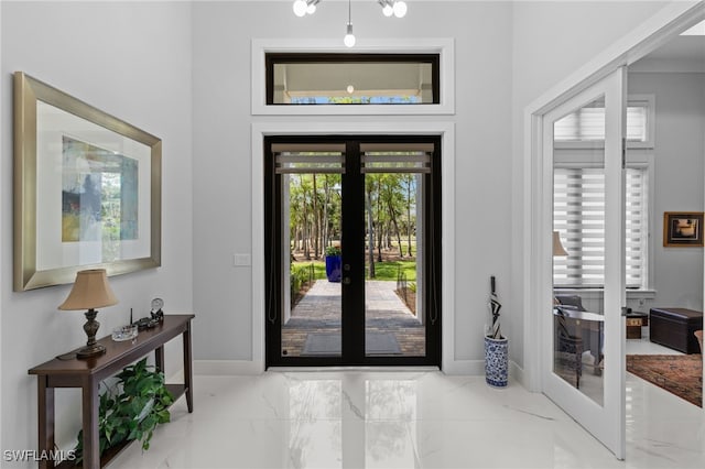 foyer with marble finish floor, french doors, and baseboards