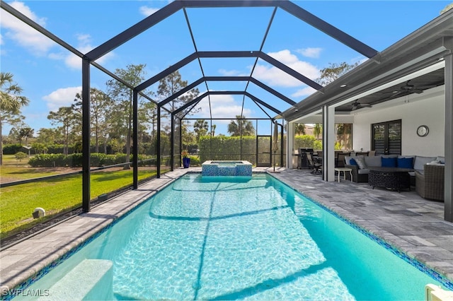 view of pool with outdoor lounge area, a pool with connected hot tub, a ceiling fan, a lawn, and a patio area