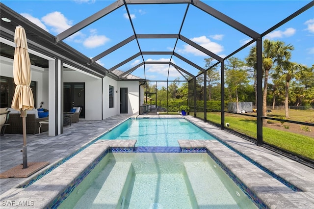 view of pool featuring a lanai, a patio area, a pool with connected hot tub, and outdoor lounge area