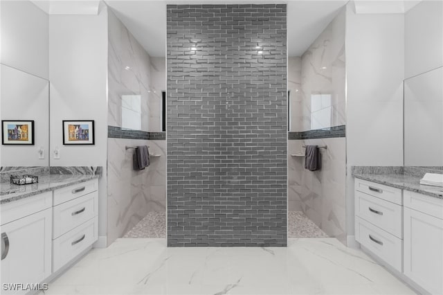 bathroom featuring a marble finish shower and vanity