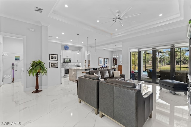 living area with marble finish floor, french doors, a tray ceiling, and crown molding