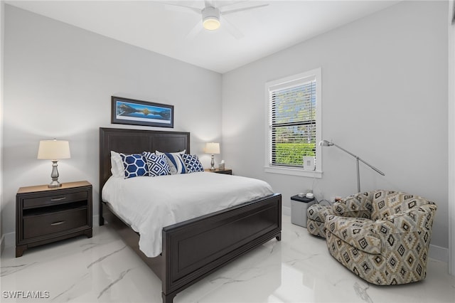 bedroom with a ceiling fan, marble finish floor, and baseboards