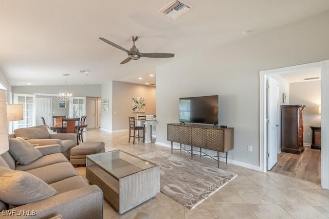 living room with light tile patterned floors, recessed lighting, visible vents, baseboards, and ceiling fan with notable chandelier