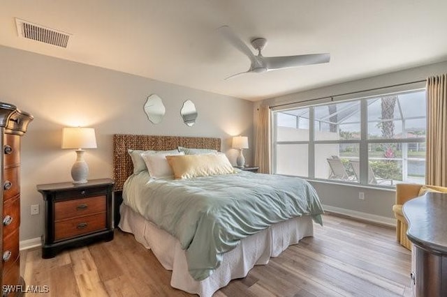 bedroom featuring light wood-type flooring, visible vents, ceiling fan, and baseboards