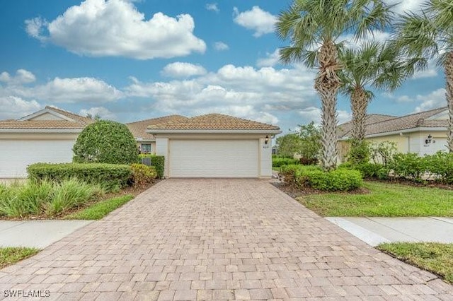 view of front of house with a garage, a tiled roof, and stucco siding