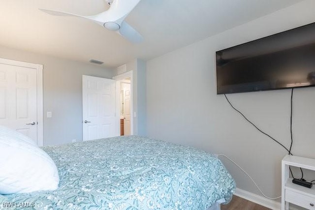 bedroom with ceiling fan, wood finished floors, visible vents, and baseboards