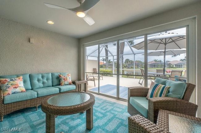 interior space featuring a sunroom, a ceiling fan, and a textured wall