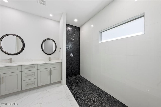 bathroom featuring double vanity, a sink, marble finish floor, and a walk in shower