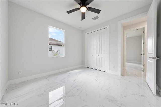 unfurnished bedroom with a closet, visible vents, marble finish floor, and baseboards