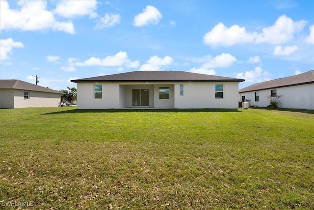 back of house with a lawn and stucco siding