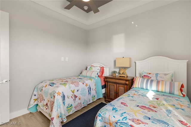 bedroom with wood finished floors, a ceiling fan, and baseboards