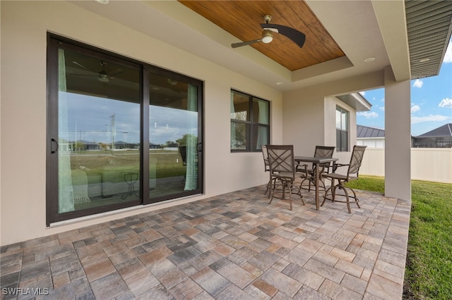 view of patio with a ceiling fan, outdoor dining space, and fence