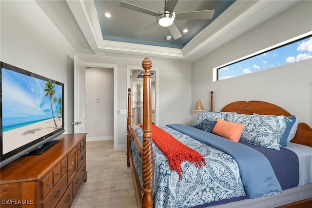 bedroom featuring a tray ceiling, recessed lighting, light wood-style flooring, ceiling fan, and baseboards