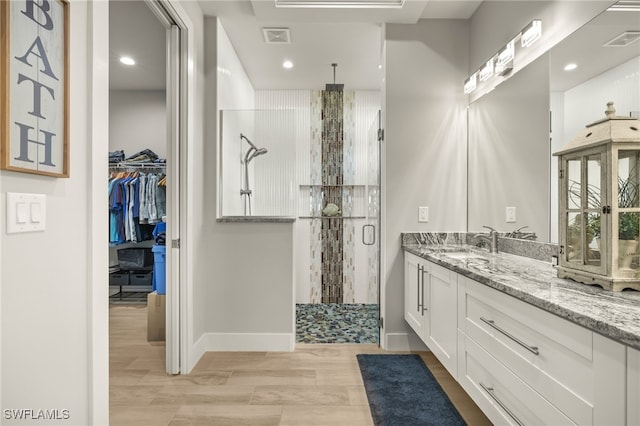 bathroom with visible vents, a shower stall, vanity, and wood finished floors