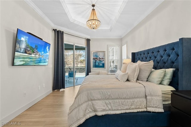 bedroom with access to exterior, crown molding, light wood-style floors, and a tray ceiling