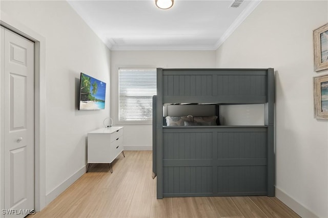 bedroom with baseboards, light wood-style flooring, and crown molding