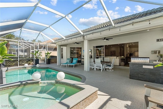 view of swimming pool featuring a lanai, a pool with connected hot tub, a patio, and a ceiling fan