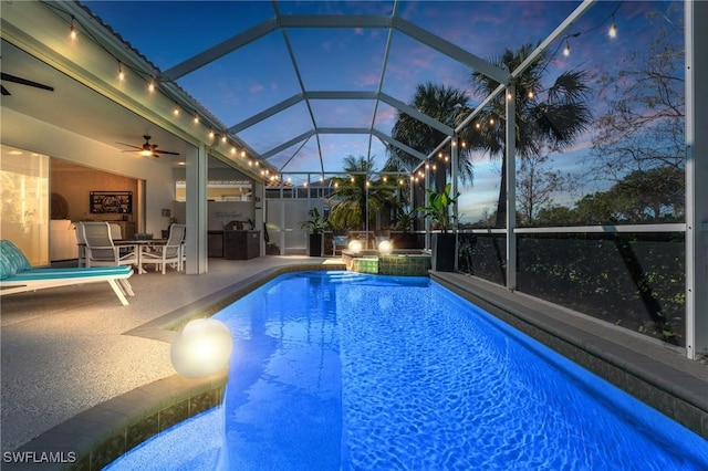 view of pool featuring area for grilling, a ceiling fan, a pool with connected hot tub, a patio, and glass enclosure